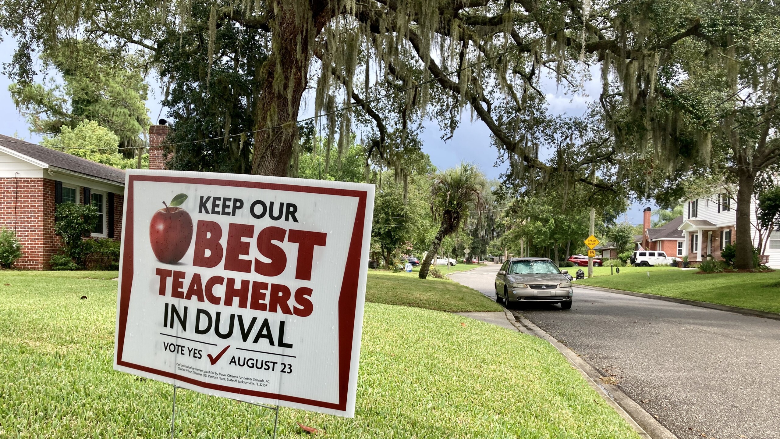 A yard sign that reads "Keep Our Best Teachers in Duval" outside a brick home.