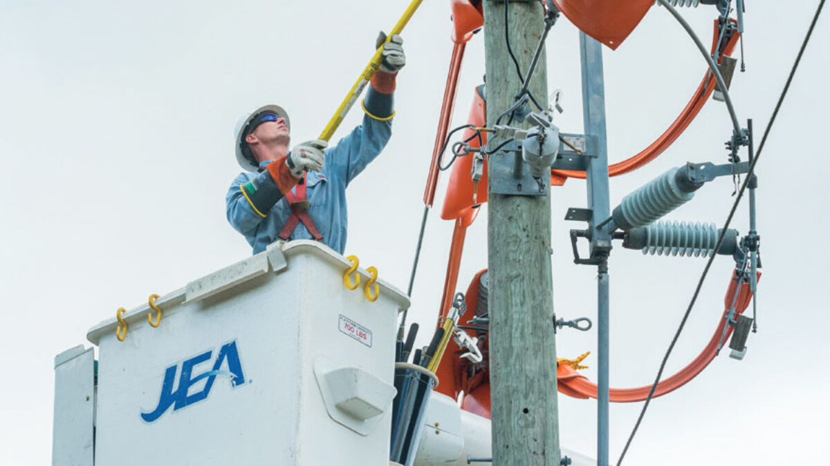 A JEA crew member works on a power line. | JEA