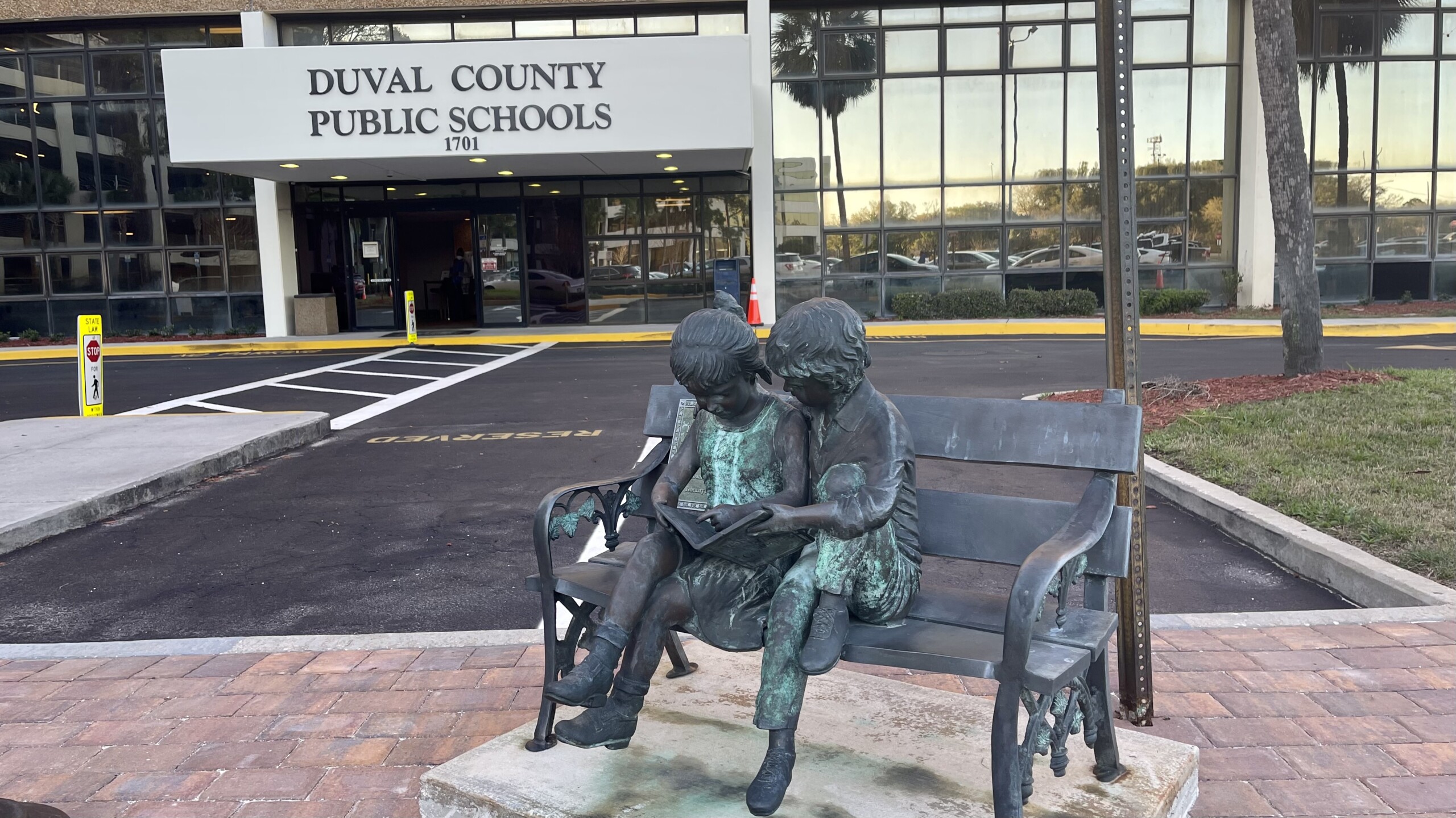 Duval County Public Schools administration building, with a bronze statue of children reading in front of it.