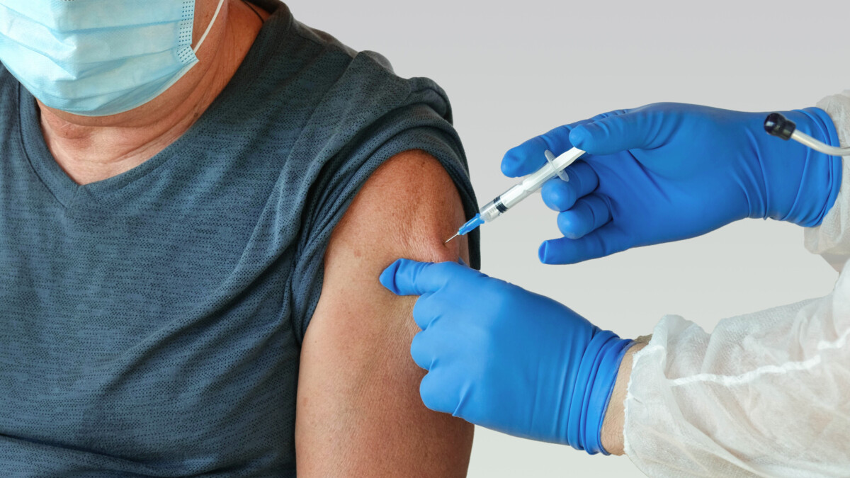 A man receives a vaccination in a clinic.