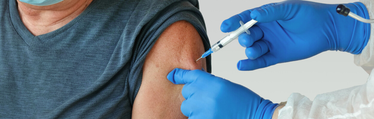A man receives a vaccination in a clinic.