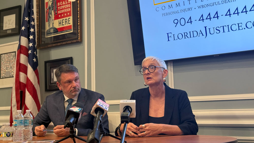 Hope McMath and her attorney, John Phillips, sit at a table with three microphones as they talk about updates in the case against her teaching license.