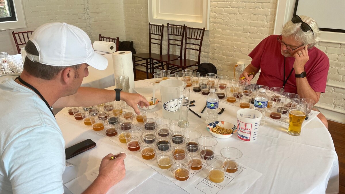 Shaun Newman, left, and Ed Stansel judge the Best in Show competition of the First Coast Cup event Saturday, July 29, 2023, at Ruby Beach Brewing in Downtown Jacksonville. | Randall Merideth
