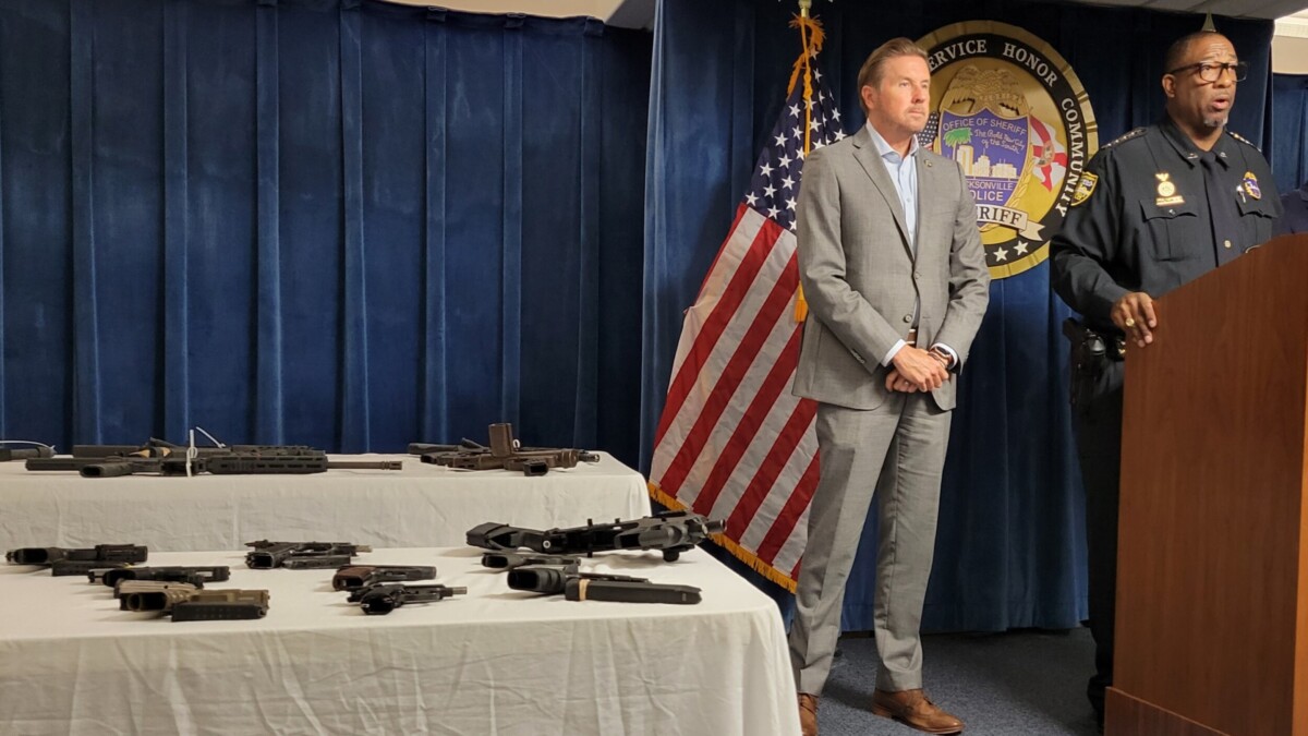 Sheriff T.K. Waters speaks at a new conference Tuesday, Aug. 8, 2023, as confiscated guns are shown nearby.