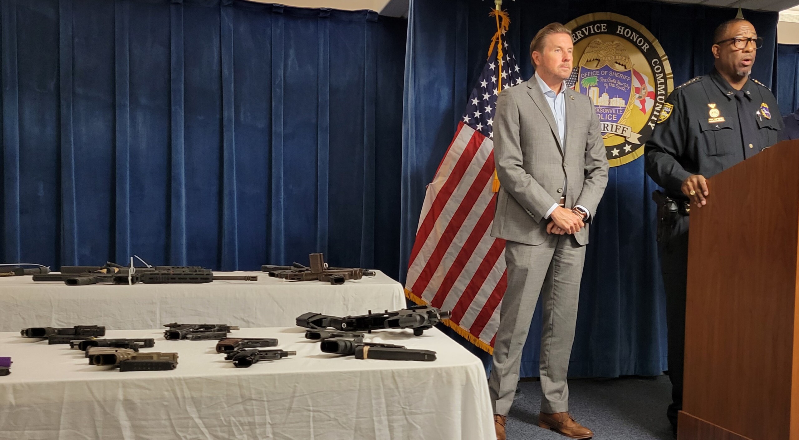 Sheriff T.K. Waters speaks at a new conference Tuesday, Aug. 8, 2023, as confiscated guns are shown nearby.