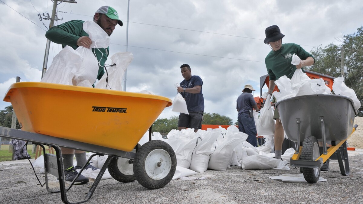Members of the Tampa, Fla., Parks and Recreation Dept., help residents with sandbags Monday, Aug. 28, 2023.