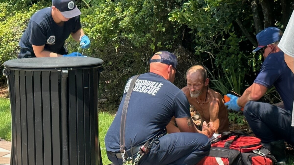 Jacksonville Fire and Rescue personnel help a man as the temperature hits 94 degrees on Aug. 1, 2023.