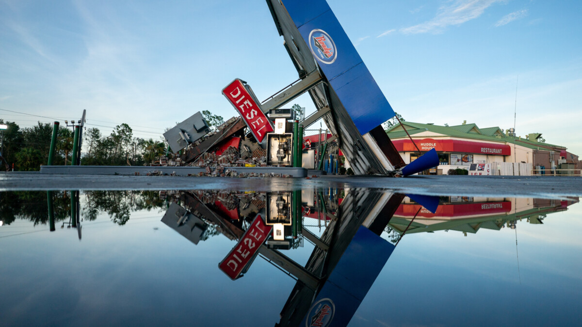 A storm-damaged gas station is reflected in a puddle after Hurricane Idalia crossed the state on Thursday, Aug. 30, 2023, in Perry.