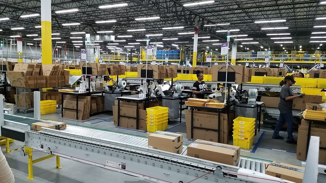 Employees work inside the city’s first Amazon fulfillment center near Jacksonville International Airport.