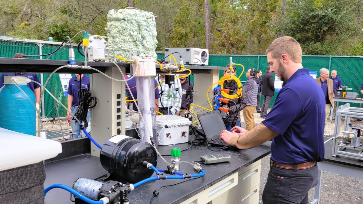 UNF graduate student Dylan Jones works on his electrolysis system, which turns water into hydrogen gas to power fuel cells. | Dan Scanlan, WJCT News 89.9
