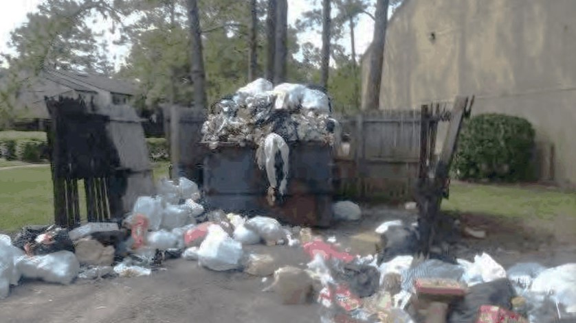 Garbage is piled high around a dumpster at the Northwoods apartment complex in this image in the city's legal action against the complex. | City of Jacksonville
