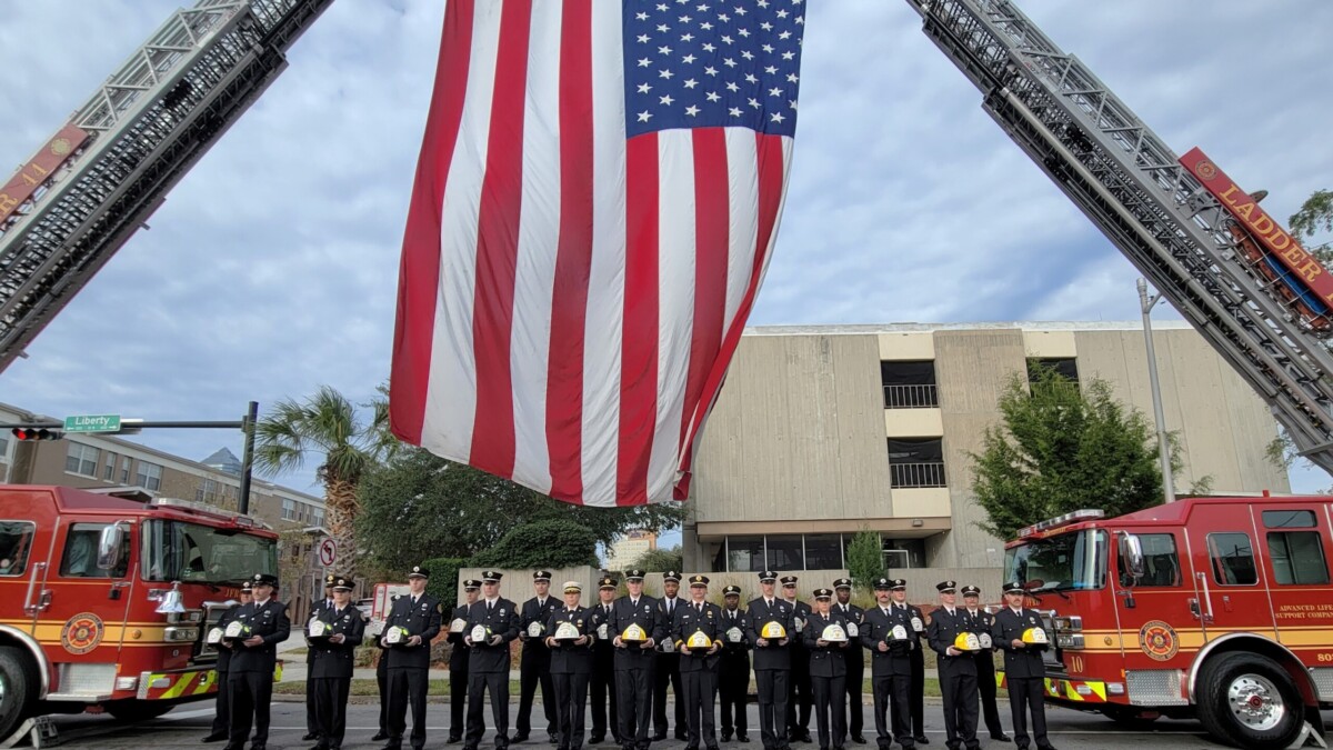 Jacksonville firefighters hold helmets bearing the names of the 25 men who have died in the line of duty since 1885. They were honored Wednesday, Dec. 13, 2023, during Fallen Firefighter Memorial Day. | Dan Scanlan, WJCT News 89.9