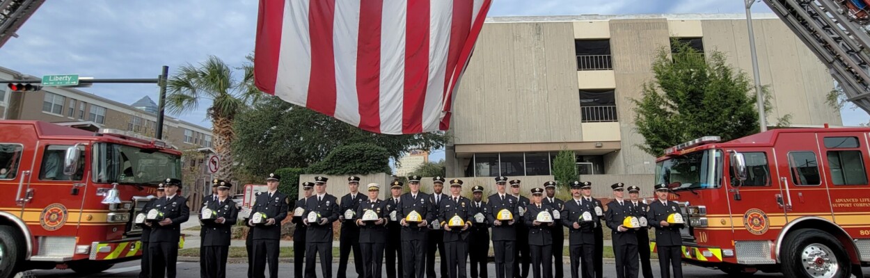 Jacksonville firefighters hold helmets bearing the names of the 25 men who have died in the line of duty since 1885. They were honored Wednesday, Dec. 13, 2023, during Fallen Firefighter Memorial Day. | Dan Scanlan, WJCT News 89.9