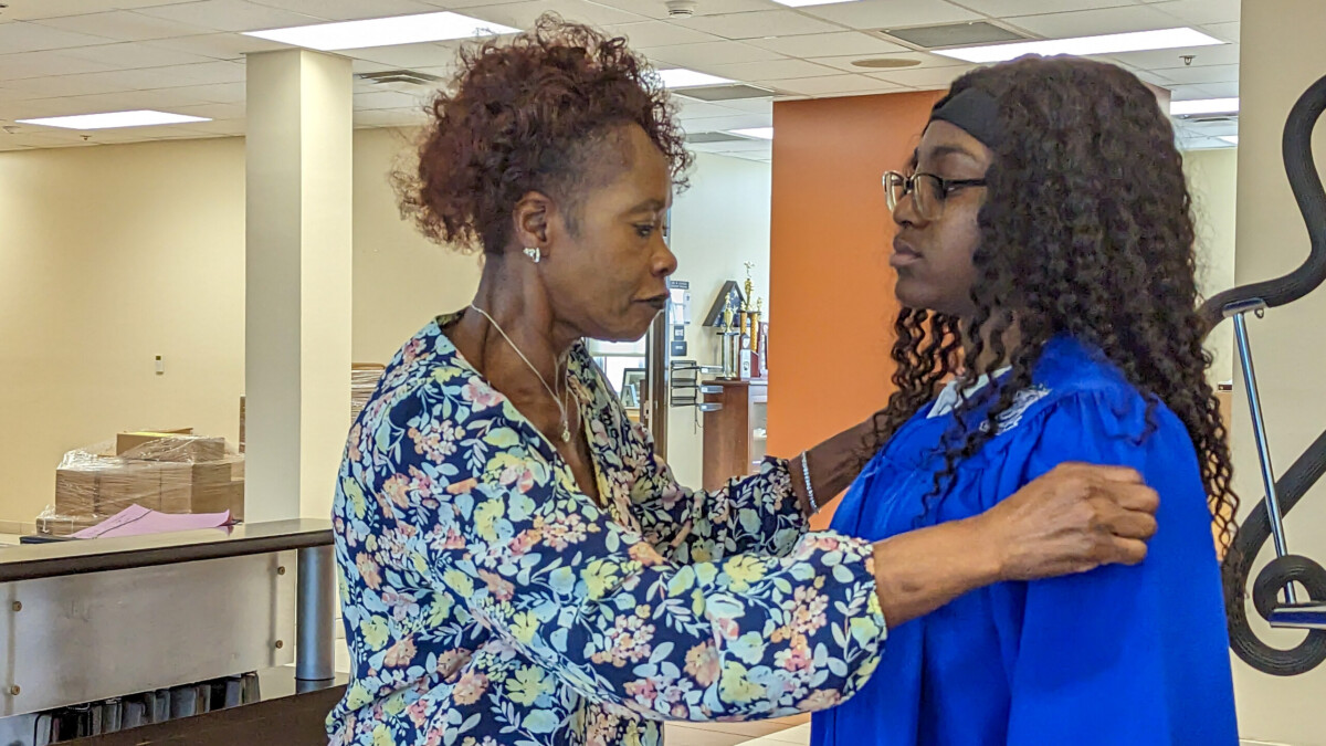 The late Mary Ella Sams, left, helps Akira Roberson put on her graduation gown on May 23, 2023. Roberson was among 7.052 Duval County Public Schools students who graduated in the 2022-23 academic year. | Will Brown, Jacksonville Today