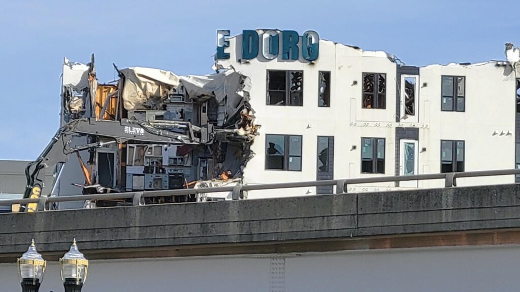 A crane armed with a claw begins tearing out chunks of the fire-ravaged Rise Doro apartment compolex early Friday, Feb. 2, 2024. | Dan Scanlan, WJCT News 89.9