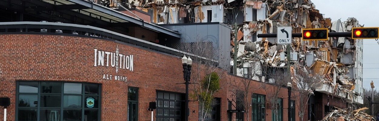 The demolition at the fire-ravaged Rise Doro apartment building can be seen behind Intuition Ale Works, which has reopened a week after the fire. | Dan Scanlan, WJCT News 89.9