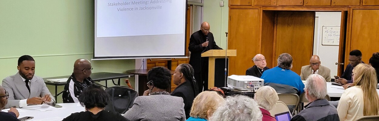 The Rev. James Bodie speaks to 100-plus people at the ICARE meeting Monday night in Arlington. | Dan Scanlan, WJCT News 89.9