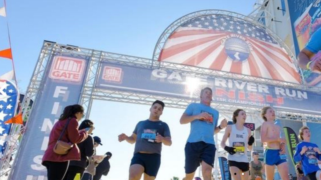Runners cruise past the finish line at the Gate River Run. | Gate River Run