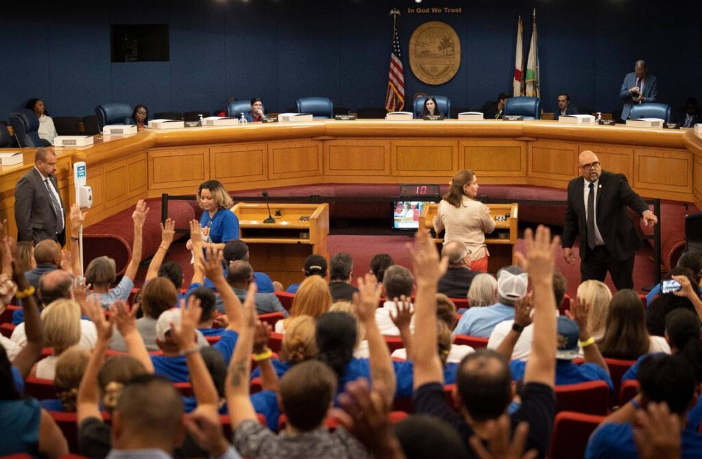 People raise their hands in support of the Miami-Dade heat standard for outdoor workers during a Miami-Dade county commission Community Health Committee meeting on Sept. 11, 2023. | Alie Skowronski, Miami Herald