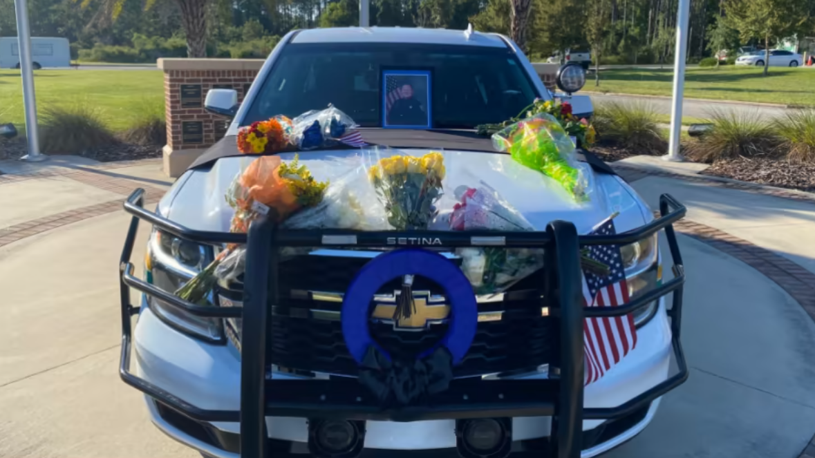 The cruiser of Nassau County Deputy Josh Moyers is decorated with memorial flowers and messages after his fatal shooting in 2021. | News4Jax