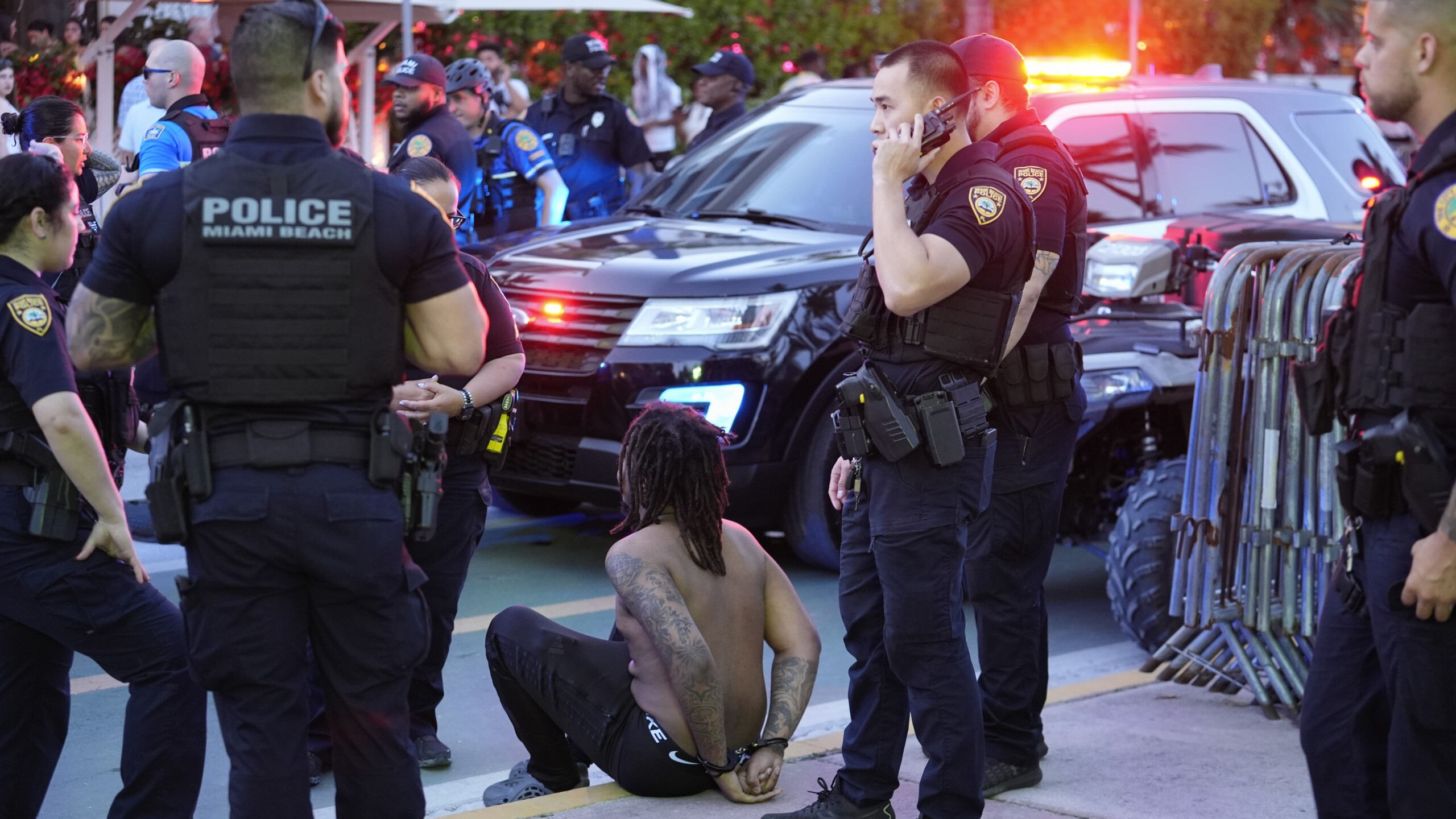 A man is temporarily handcuffed as police patrol en masse along Ocean Drive in Miami Beach on March 15, 2024/ | Rebecca Blackwell, AP