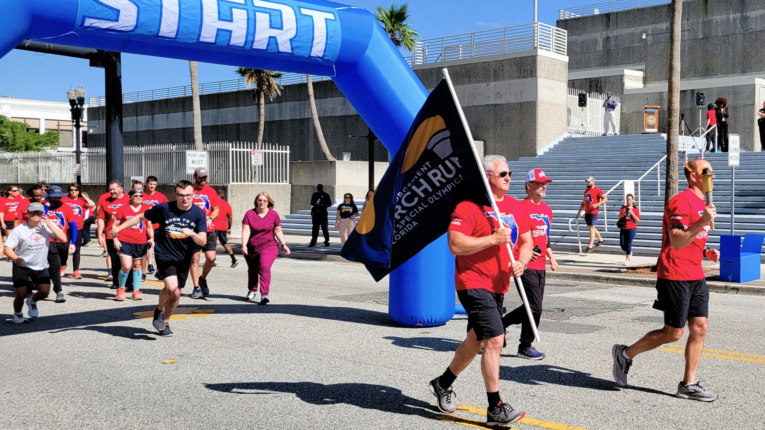 More than 100 law enforcement officers carry the Special Olympics “Flame of Hope” through Jacksonville on Tuesday, April 23, 2024. Chief Jonathan Barrier leads the way with the flame. | Dan Scanlan, Jacksonville Today