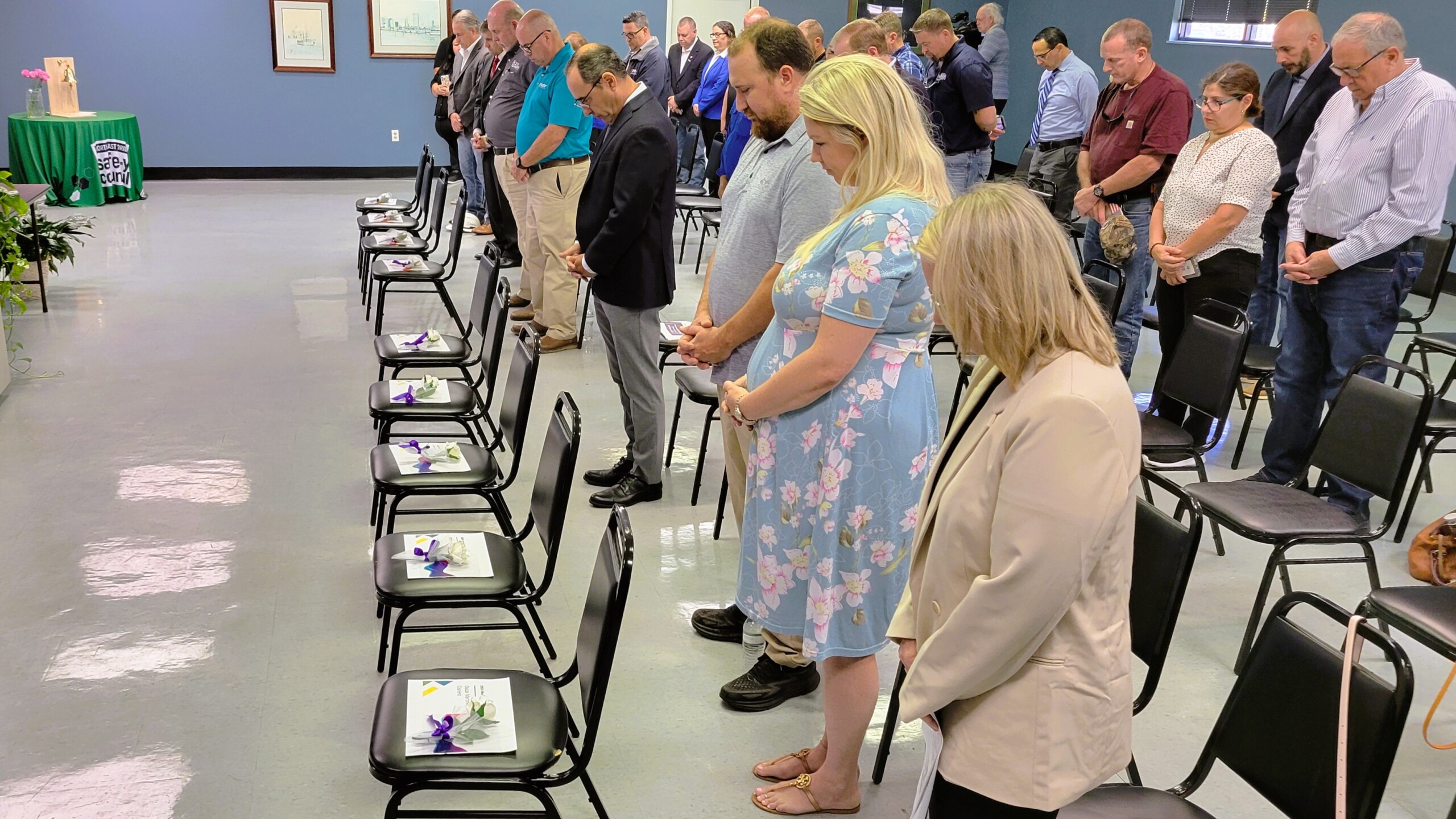 Audience members bow their heads in prayer Friday, April 26, 2024, as nine workers who died on the job last year in North Florida are remembered. Their names are displayed on cards on the empty row of chairs at the Northeast Florida Safety Council's Workers’ Memorial ceremony. | Dan Scanlan, Jacksonville Today