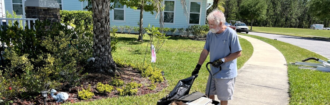 Martin Newman, a resident of the TrailMark neighborhood in St. Johns County, cleans up his lawn Friday, April 12, 2024, after a tornado touched down not far from his home. | Noah Hertz, Jacksonville Today.