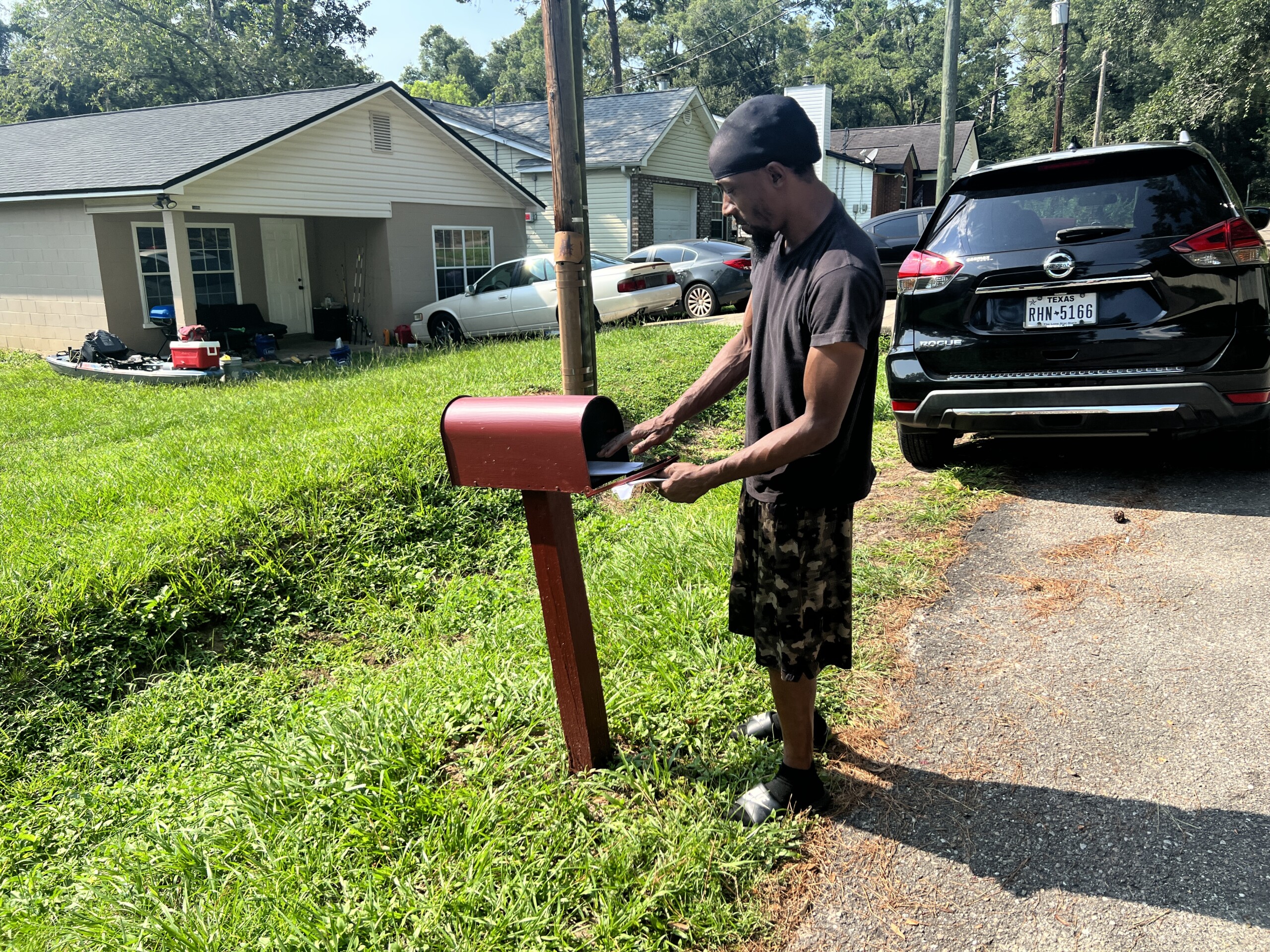 Tallahassee resident Julian Boise puts a completed voter registration form in his mailbox after volunteers with the Big Bend Voting Rights Project visited his home on the city's South Side on August, 19, 2023. | Valerie Crowder
