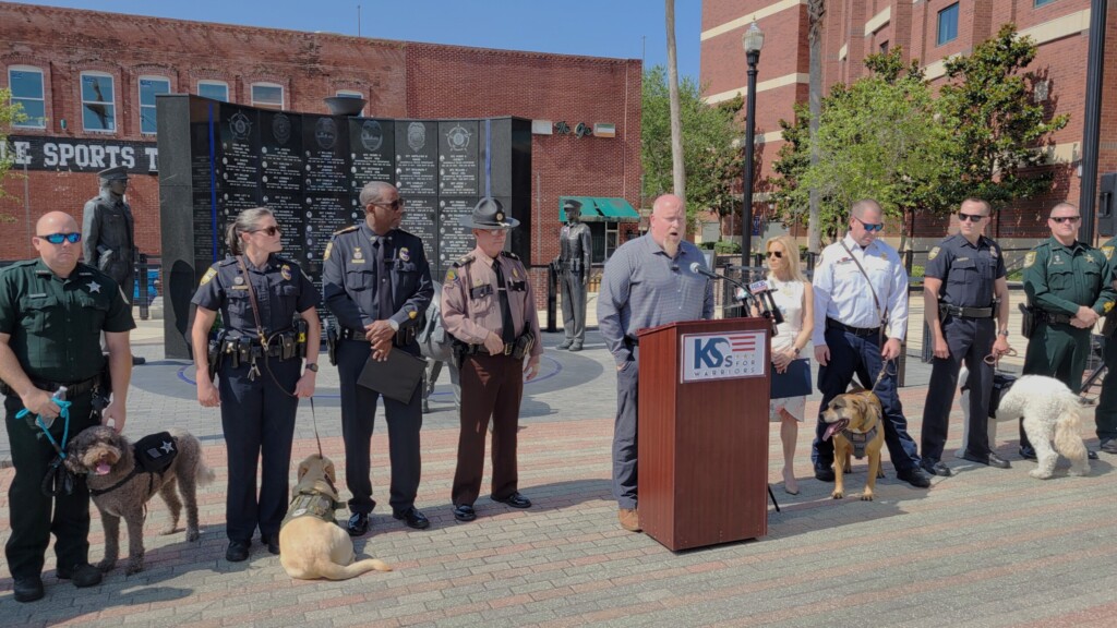 Greg Wells, director of the Station Dog Program for K9s For Warriors, speaks with law enforcement members and their dogs on Tuesday, May 7, 2024, at at the Police Memorial. | Dan Scanlan, Jacksonvillle Today