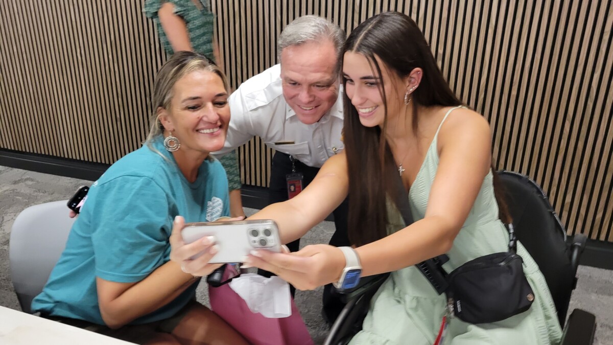 Ponte Vedra High School senior Madison Schemitz, right, shoots a selfie with her mother, Jacqueline Rogue, and Jacksonville Fire and Rescue Department Lt. Matt Avera. They were at the trauma survivors day event Thursday, May 16, 2024, at HCA Jacksonville Memorial Hospital. | Dan Scanlan, Jacksonville Today