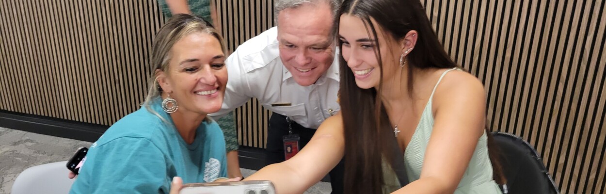 Ponte Vedra High School senior Madison Schemitz, right, shoots a selfie with her mother, Jacqueline Rogue, and Jacksonville Fire and Rescue Department Lt. Matt Avera. They were at the trauma survivors day event Thursday, May 16, 2024, at HCA Jacksonville Memorial Hospital. | Dan Scanlan, Jacksonville Today