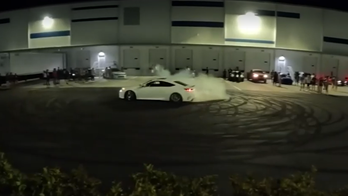 A driver does a burnout in a parking lot. as a crowd watches. | Jacksonville Sheriff's Office, News4Jax