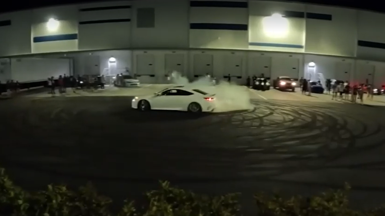 A driver does a burnout in a parking lot. as a crowd watches. | Jacksonville Sheriff's Office, News4Jax