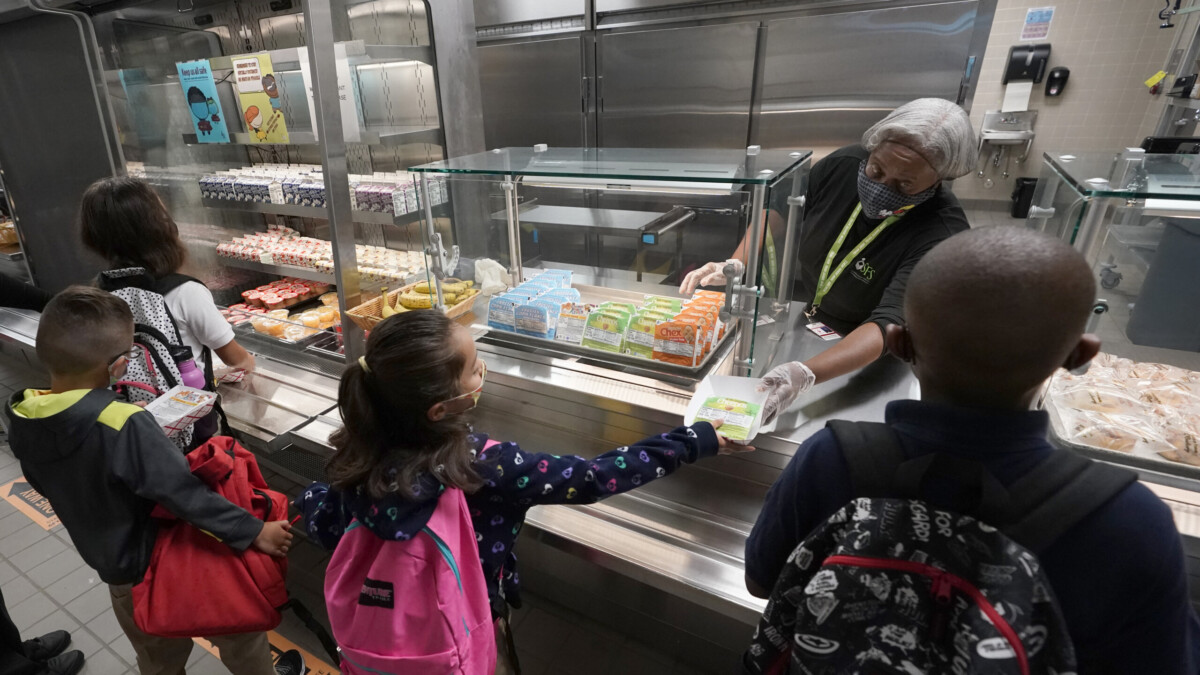 Food service assistant Brenda Bartee gives students breakfast at Washington Elementary School in Riviera Beach in August 2021. | Wilfredo Lee, AP
