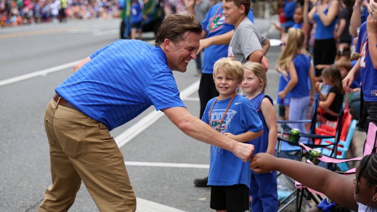 University of Florida President Ben Sasse fist-bumps kids during UF's Homecoming Parade in Gainesville in 2023. | Ashleigh Lucas, WUFT News)