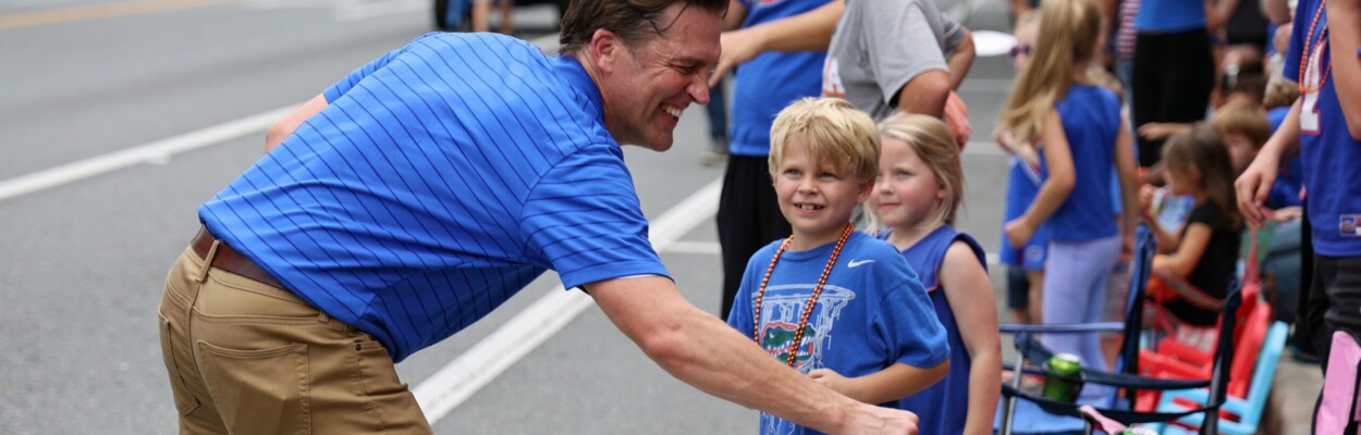 University of Florida President Ben Sasse fist-bumps kids during UF's Homecoming Parade in Gainesville in 2023. | Ashleigh Lucas, WUFT News)