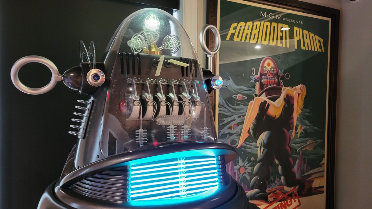 A replica of the Robby the Robot that appeared in the 1950s sci-fi film "Forbidden Planet" lights up as it speaks lines from the film. A poster of the film is displayed near it. | Dan Scanlan, Jacksonville Today