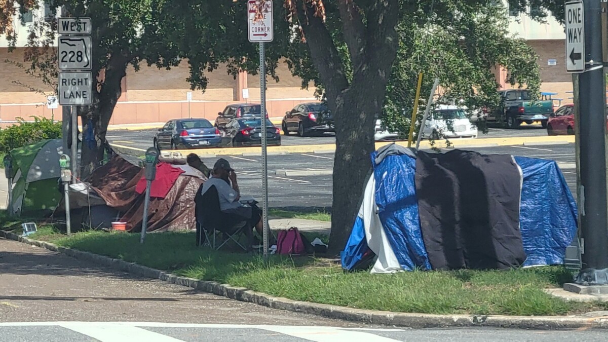 Homeless people sit outside tents on East Adams Street in Downtown Jacksonville, near North Liberty Street. | Dan Scanlan, Jacksonville Today