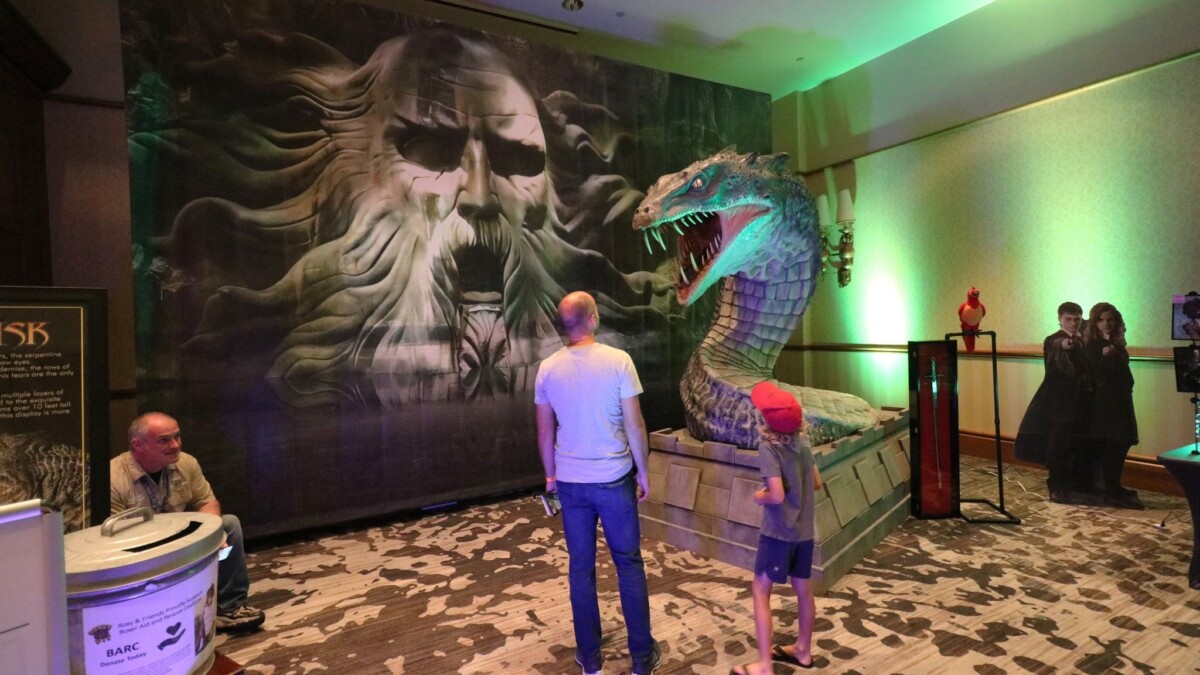 Fans at last year's Enchantment Con gaze at a statue of a basilisk — a fictional serpent-like creature. | Enchantment Con