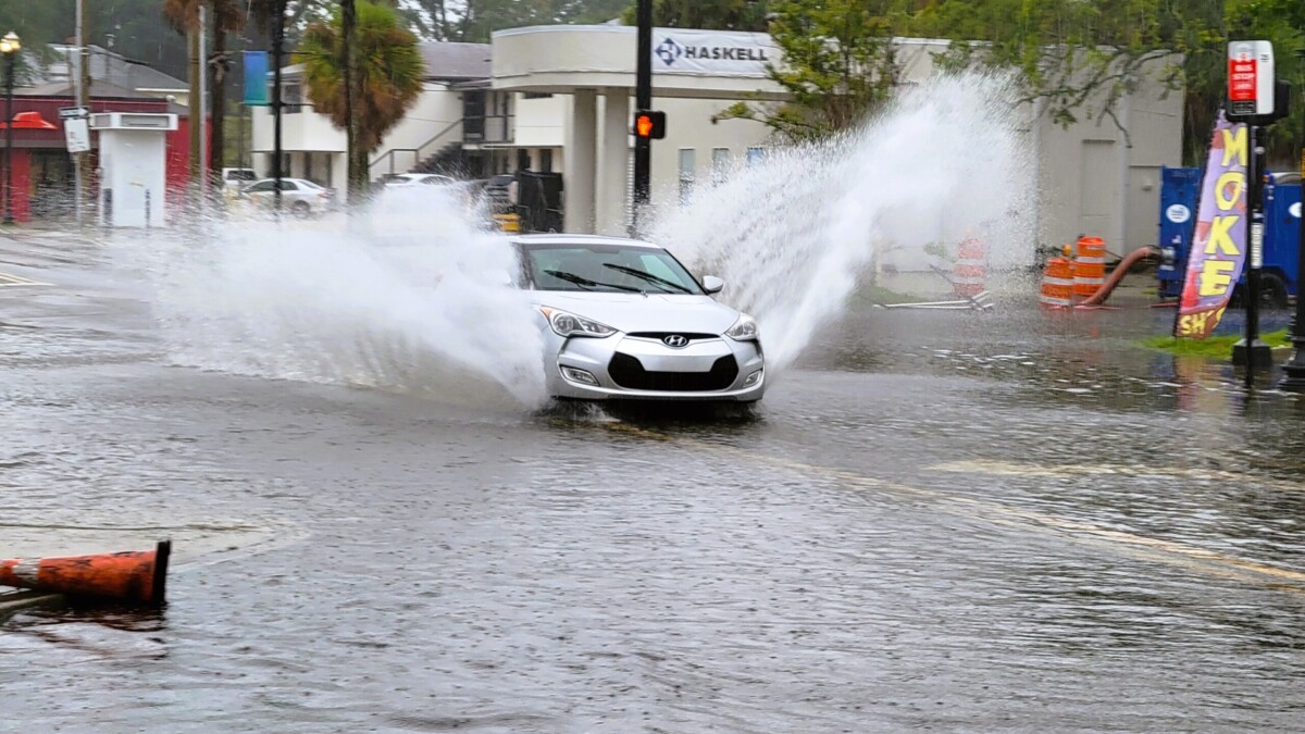 A car splashes through the flooded San Marco Boulevard intersection with LaSalle Street on Monday morning, Aug. 5, 2024. | Dan Scanlan, Jacksonville Today