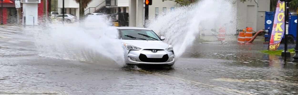 A car splashes through the flooded San Marco Boulevard intersection with LaSalle Street on Monday morning, Aug. 5, 2024. | Dan Scanlan, Jacksonville Today