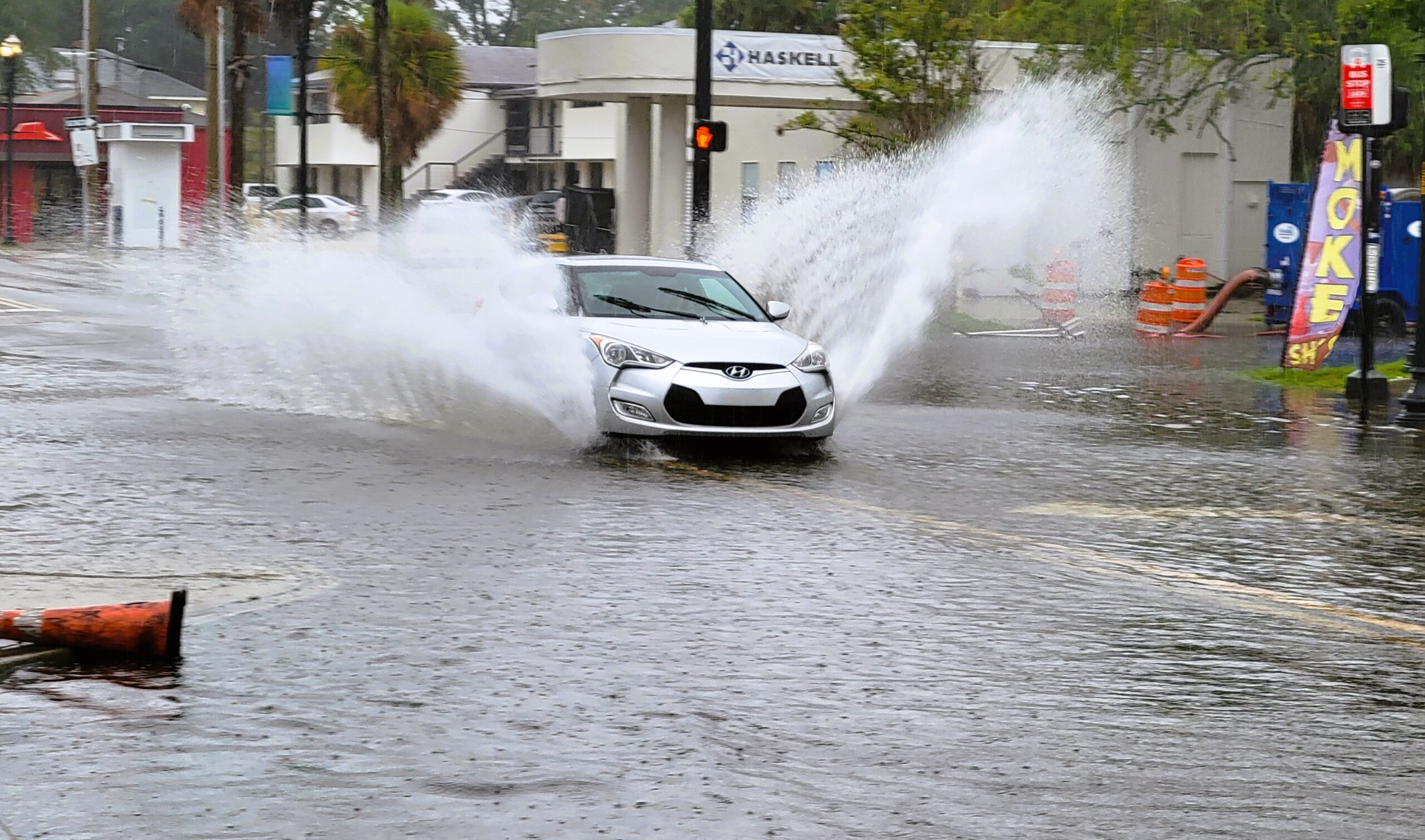 A car splashes through the flooded San Marco Boulevard intersection with LaSalle Street on Monday morning, Aug. 5, 2024. | Dan Scanlan, Jacksonville Today