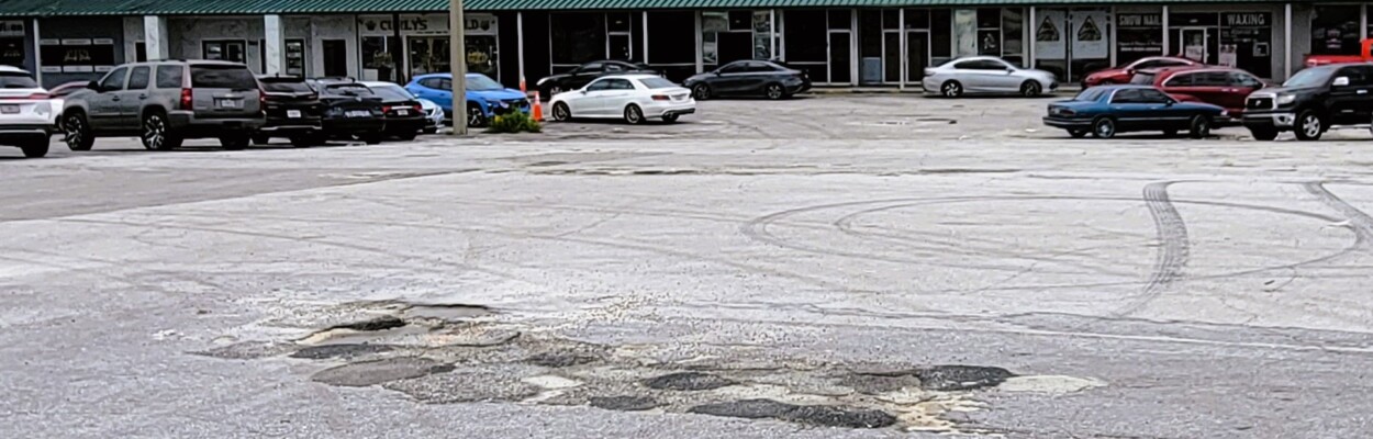 Dozens of potholes pockmark the Norwood Plaza parking lot. | Dan Scanlan, Jacksonville Today