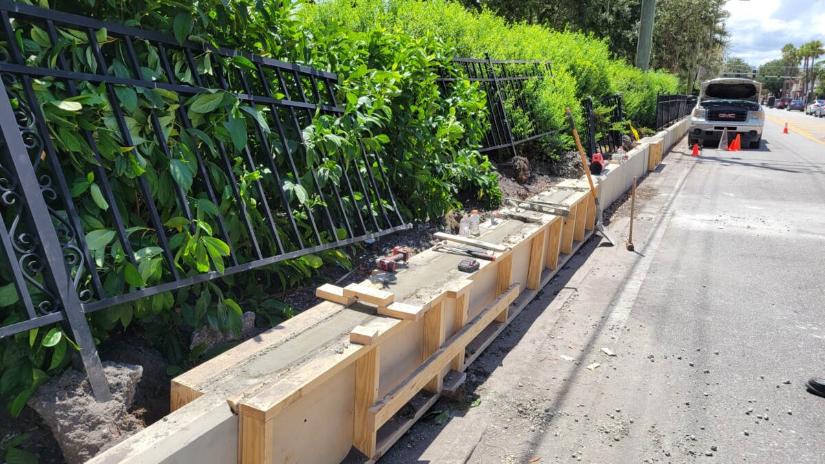 A new support wall was being laid Friday, Aug. 23, 2024, at Memorial Park. The metal fence damaged in a vehicle crash remained to be fixed. | Dan Scanlan, Jacksonville Today