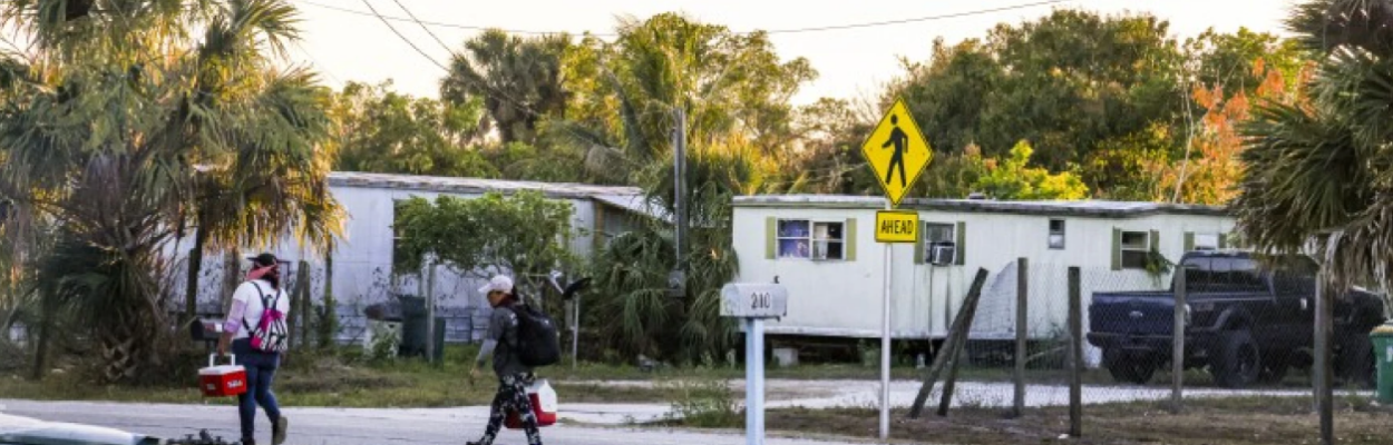 A couple of farmworkers walk home in Immokalee after Hurricane Irma struck the small town in 2017. | Andrea Melendez, WGCU