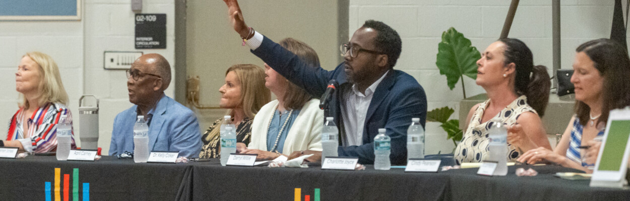 Duval County School Board member Darryl Willie, in sports coat and light-colored shirt, raises his hand in a meeting.