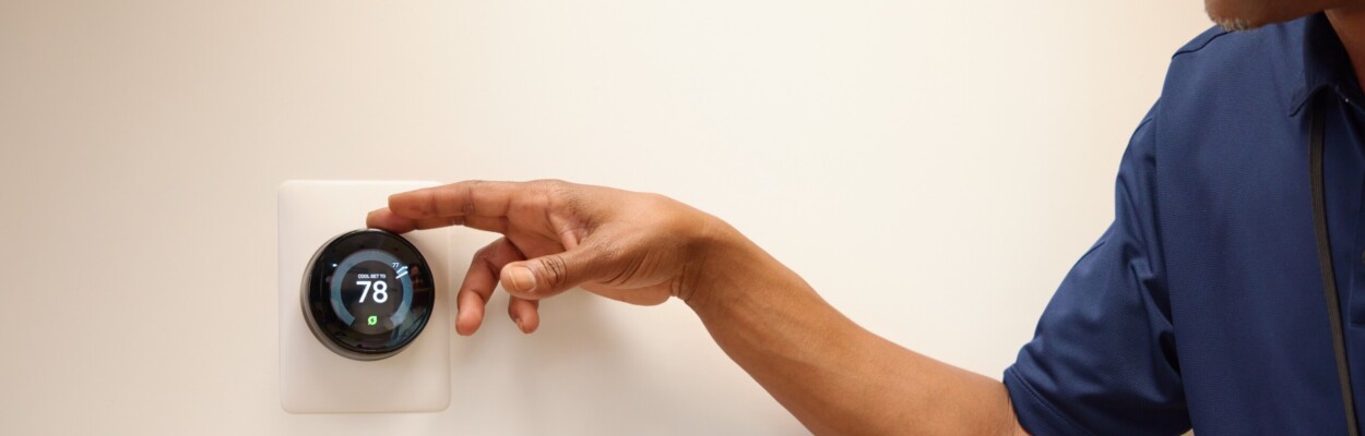 A man adjusting a thermostat