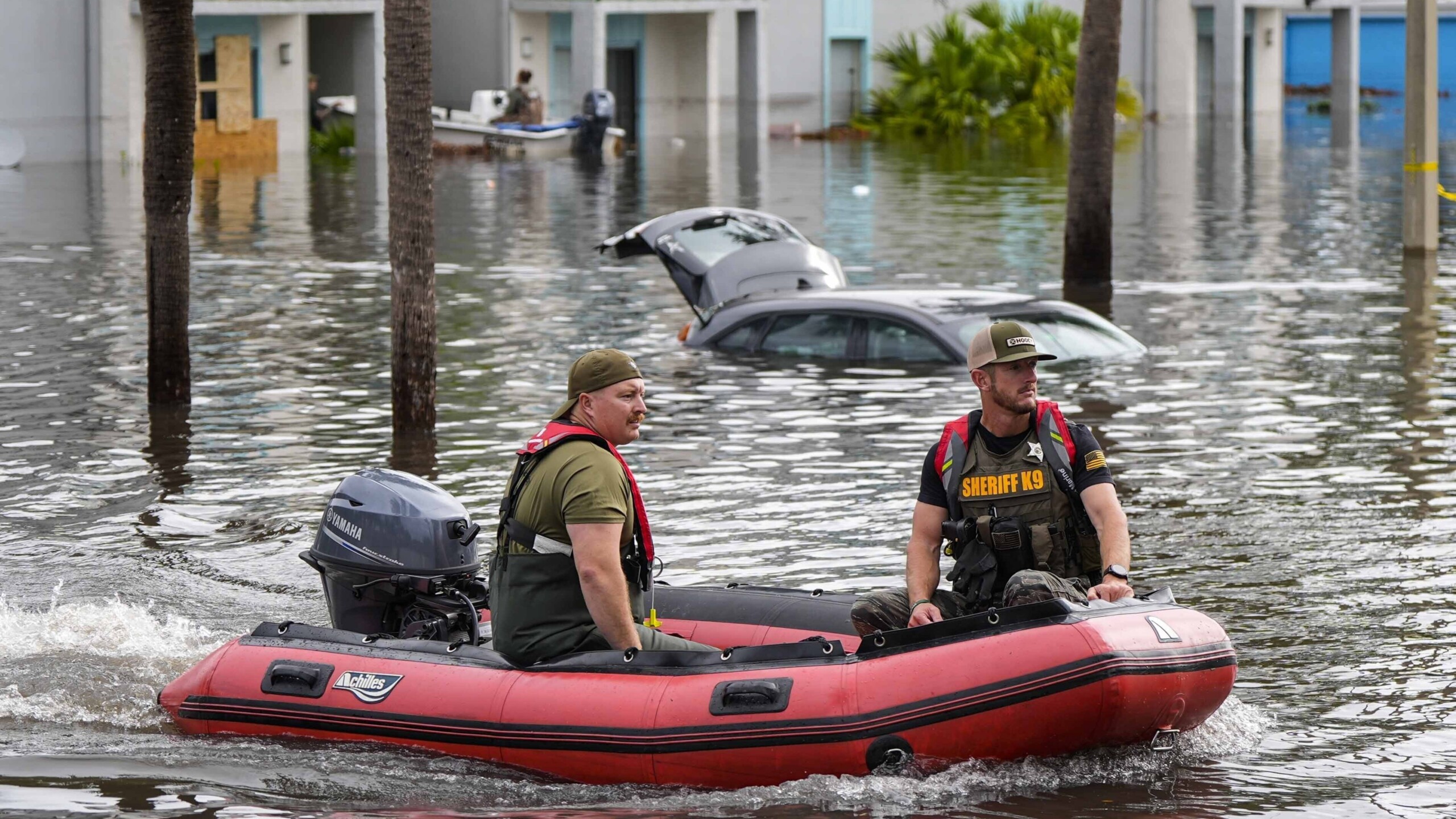 Two rescuers in a boat after Hurricane Milton