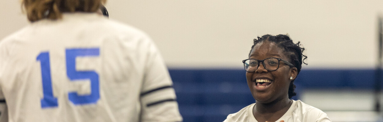 Ribault junior Jasmine Delphonse applauding Trojans setter Rivka Woolf
